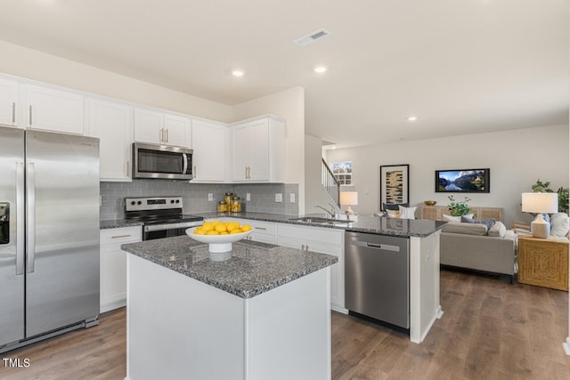 kitchen with white cabinetry, dark hardwood / wood-style flooring, a center island, sink, and appliances with stainless steel finishes