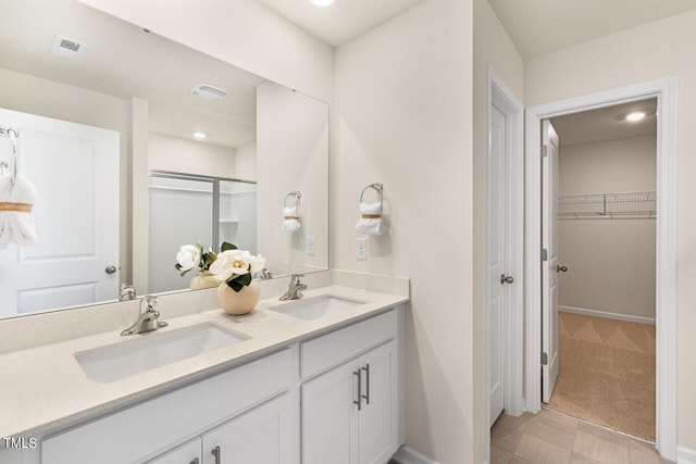 bathroom with a shower with door and vanity