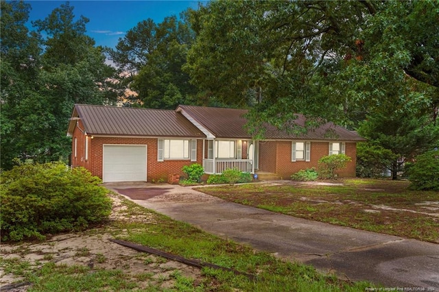 ranch-style home with a porch and a garage