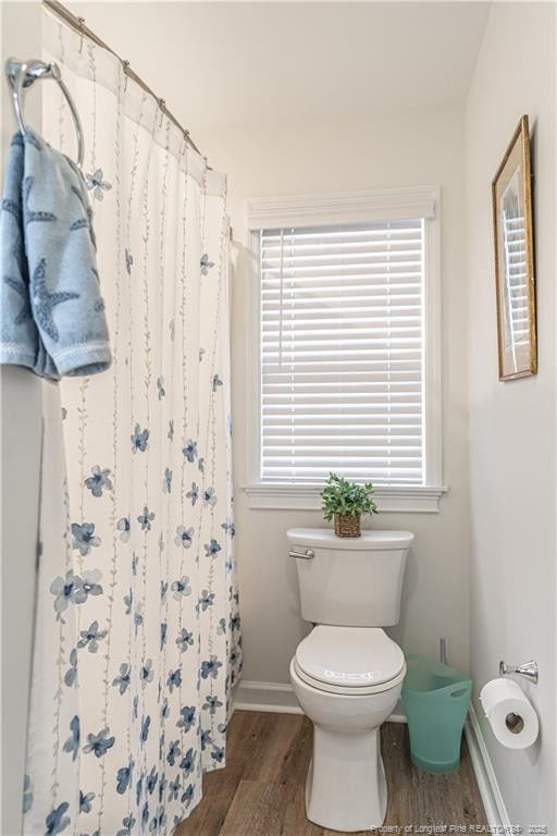 bathroom featuring a shower with curtain, baseboards, toilet, and wood finished floors