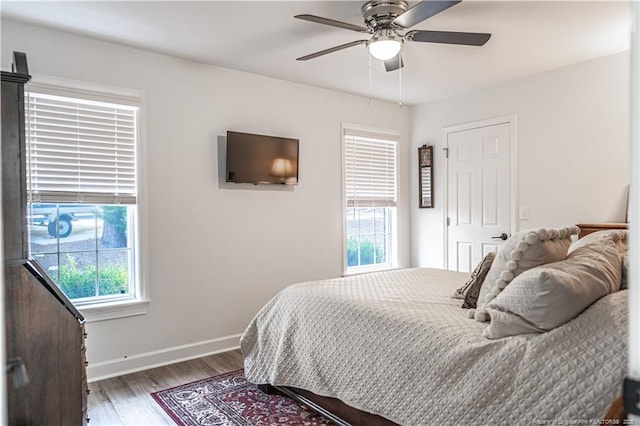 bedroom featuring ceiling fan, wood finished floors, and baseboards