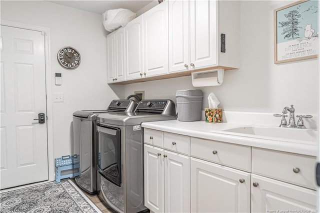 laundry room featuring washer and clothes dryer, a sink, and cabinet space