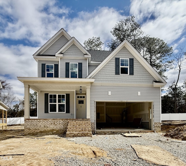 craftsman inspired home featuring a garage, covered porch, driveway, and fence