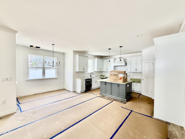 kitchen featuring a center island, black dishwasher, light countertops, backsplash, and a sink