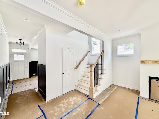 interior space featuring ornamental molding, wood finished floors, and baseboards