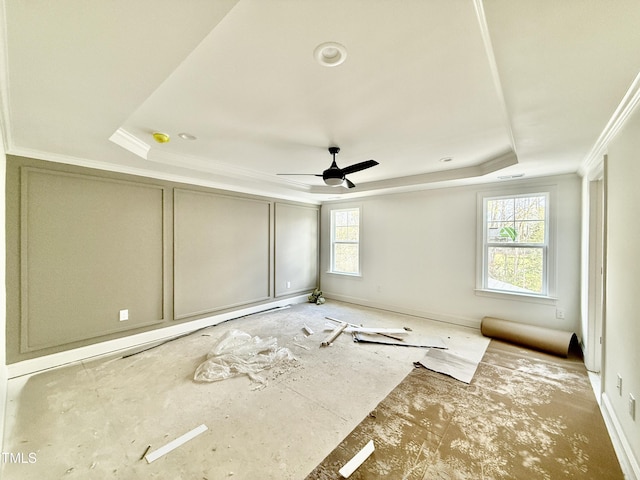 unfurnished room featuring a ceiling fan, a raised ceiling, and crown molding