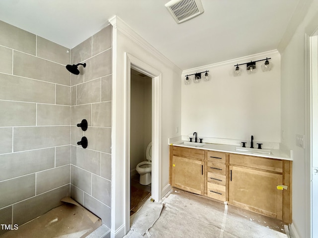 full bathroom with toilet, visible vents, a tile shower, and a sink