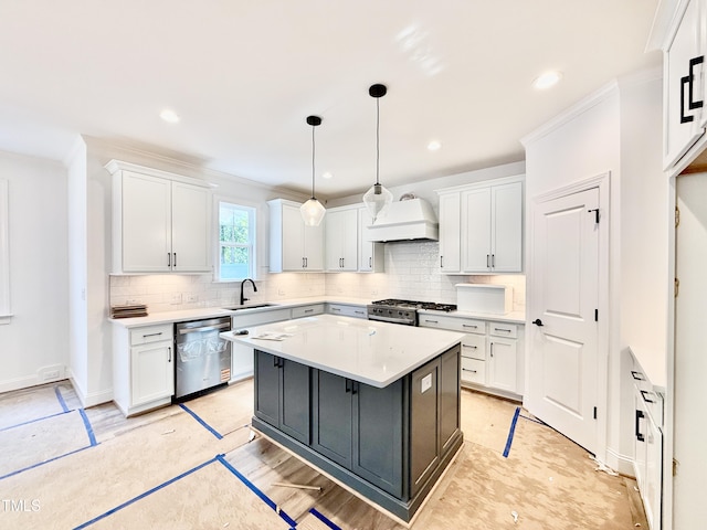 kitchen featuring crown molding, white cabinets, custom range hood, a sink, and stainless steel appliances
