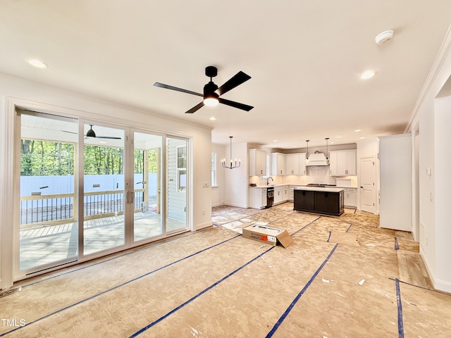 unfurnished living room with crown molding, baseboards, plenty of natural light, and ceiling fan