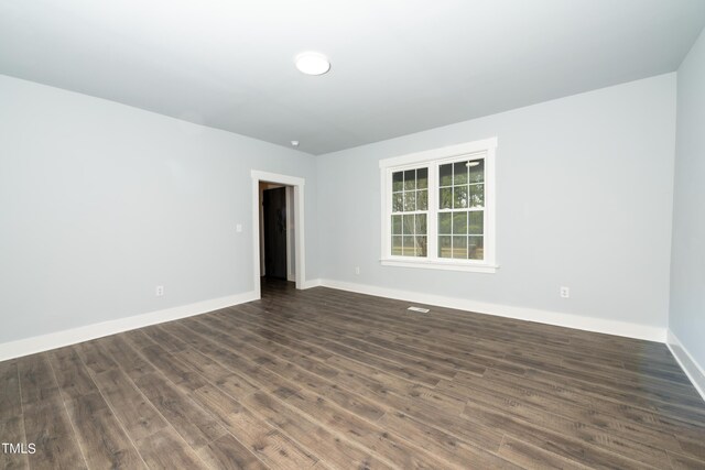 unfurnished room with dark wood finished floors and baseboards