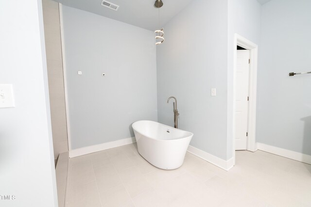 bathroom featuring a freestanding tub, visible vents, and baseboards