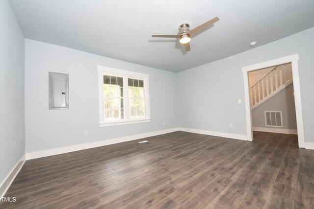 spare room featuring visible vents, electric panel, dark wood-style floors, stairway, and baseboards