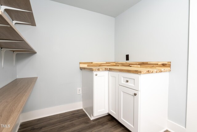 laundry room with baseboards and dark wood-style floors