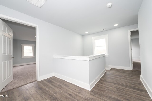 hall featuring visible vents, dark wood-type flooring, baseboards, an upstairs landing, and recessed lighting