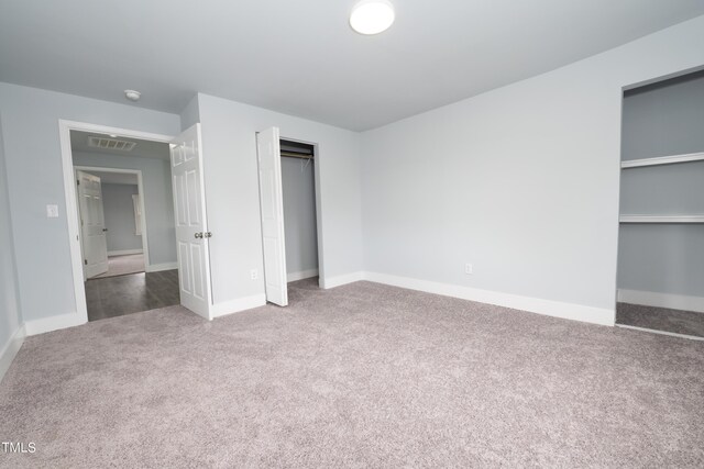 unfurnished bedroom with visible vents, baseboards, a closet, and carpet floors