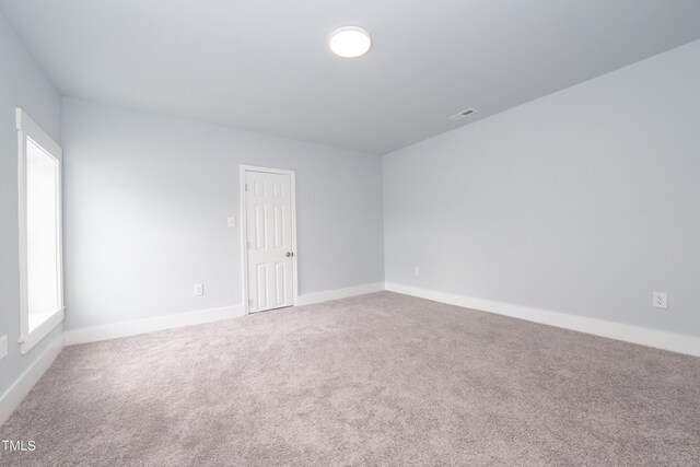 empty room featuring visible vents, baseboards, and carpet floors