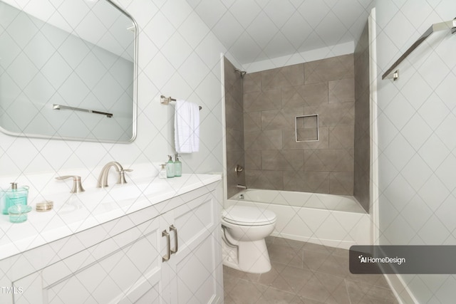 bathroom featuring vanity, tile patterned flooring, tiled shower / bath combo, tile walls, and toilet