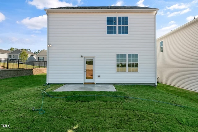 rear view of house with a yard and a patio