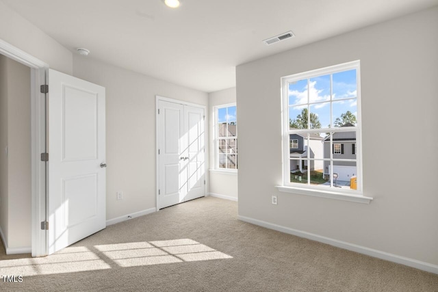 unfurnished bedroom featuring light carpet