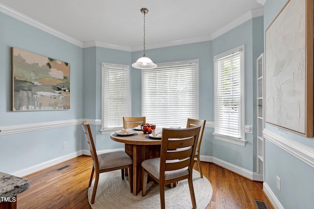 dining area featuring hardwood / wood-style floors and ornamental molding