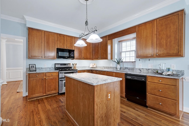 kitchen with dark hardwood / wood-style flooring, ornamental molding, a kitchen island, pendant lighting, and black appliances