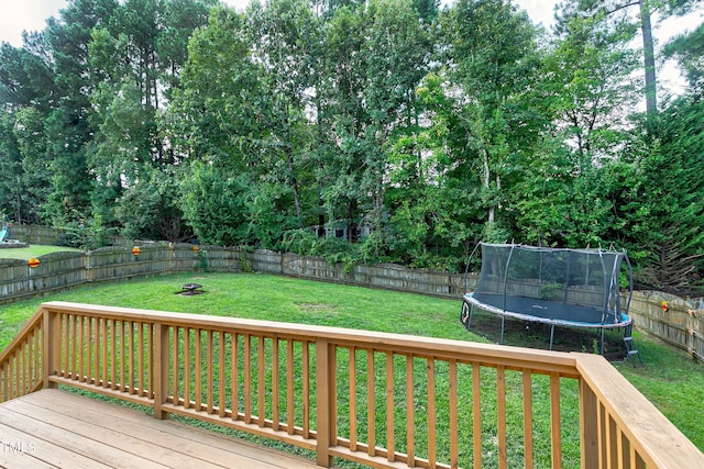 wooden terrace with a lawn and a trampoline