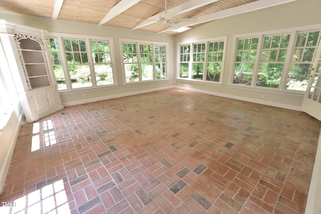 unfurnished sunroom with a skylight, ceiling fan, wood ceiling, and plenty of natural light