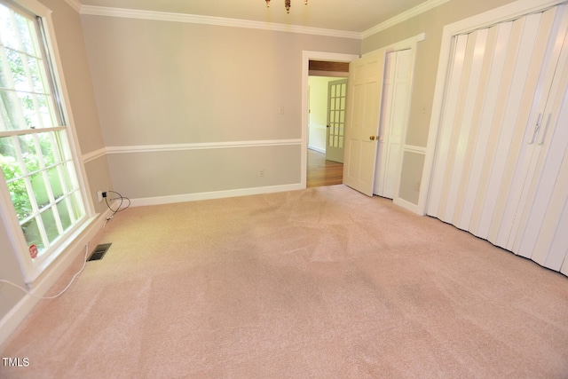 interior space with crown molding and light colored carpet