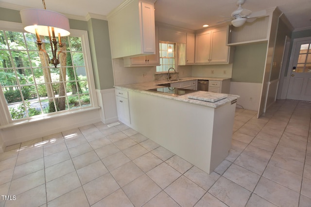 kitchen with pendant lighting, ceiling fan with notable chandelier, white cabinetry, kitchen peninsula, and sink