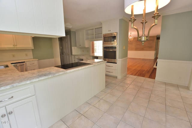 kitchen with white cabinets, crown molding, appliances with stainless steel finishes, kitchen peninsula, and light tile patterned flooring