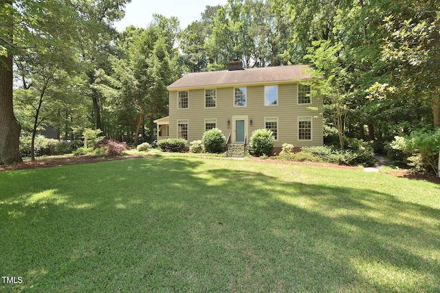 colonial-style house featuring a front yard