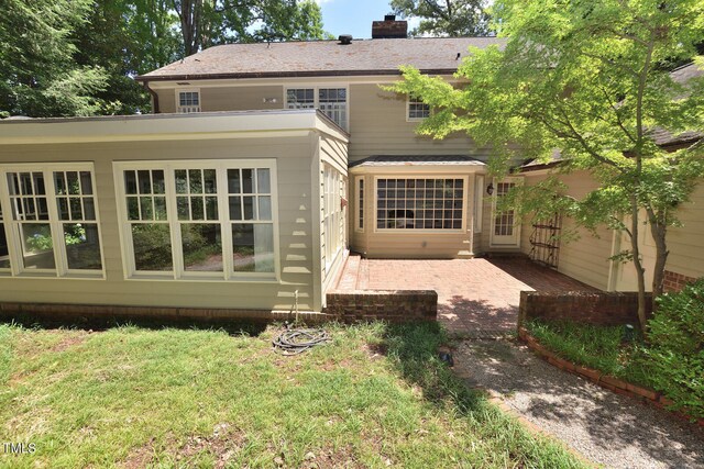 back of property featuring a yard and a patio