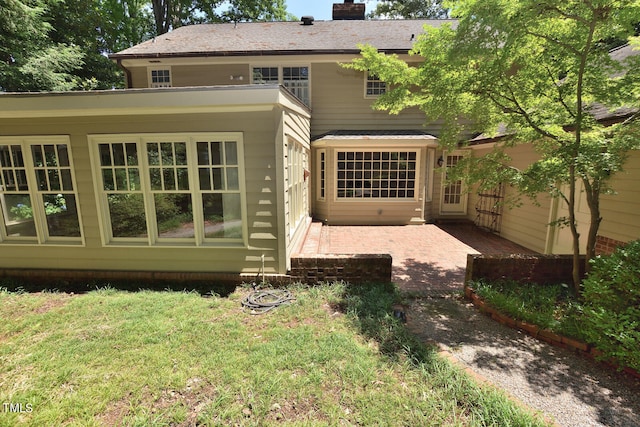 back of property featuring a yard and a patio