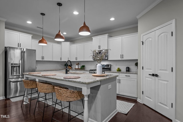 kitchen featuring hanging light fixtures, appliances with stainless steel finishes, sink, and white cabinets