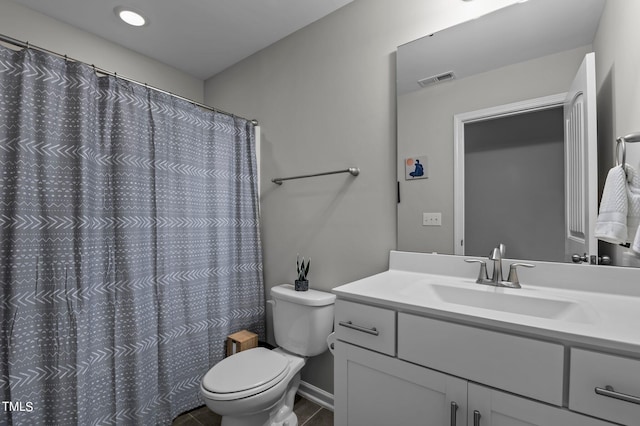 bathroom featuring vanity, walk in shower, and toilet