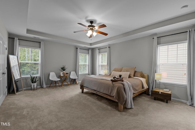 bedroom featuring carpet floors, ceiling fan, and a tray ceiling