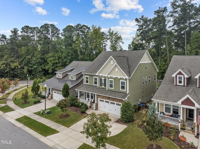 craftsman inspired home with a garage, a porch, and a front yard