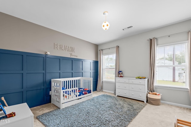 carpeted bedroom featuring a crib