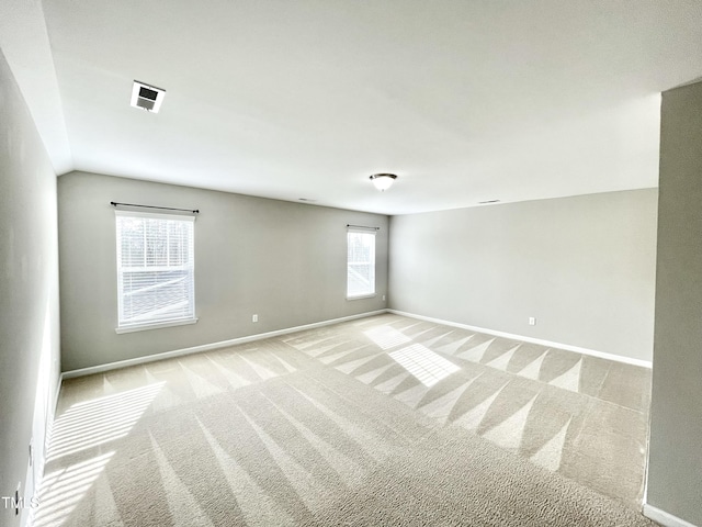 carpeted spare room with vaulted ceiling