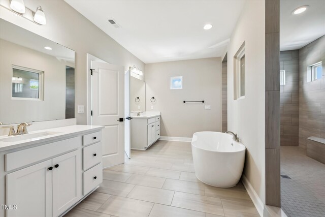 bathroom featuring tile patterned flooring, vanity, and plus walk in shower