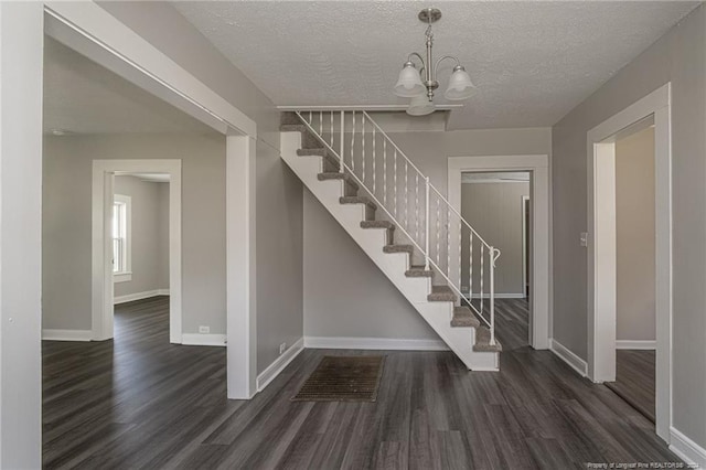 111 Sanford Rd, Laurinburg, NC 28352 - stairs featuring an inviting chandelier, a textured ceiling, baseboards, and wood finished floors
