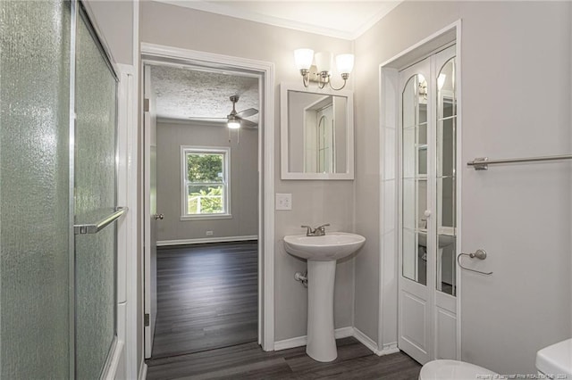 111 Sanford Rd, Laurinburg, NC 28352 - full bath featuring baseboards, toilet, ornamental molding, wood finished floors, and an enclosed shower