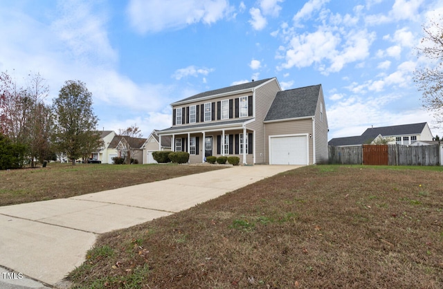 view of front of home featuring covered porch, a front yard, and a garage