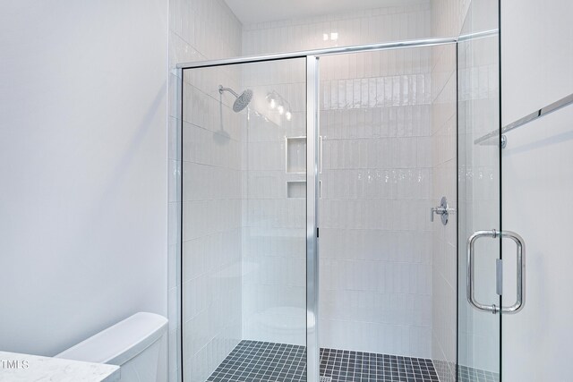 bathroom with walk in shower and toilet