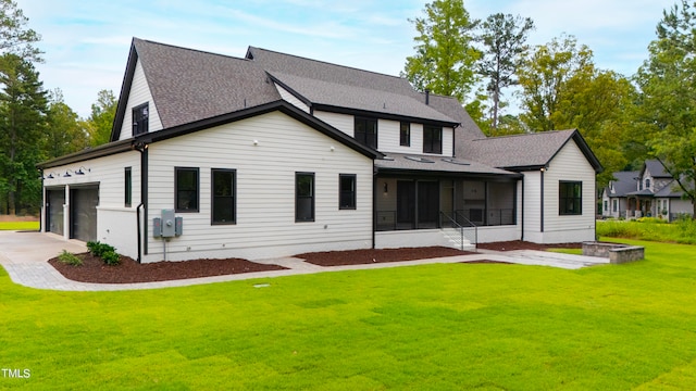 rear view of house with a garage and a yard