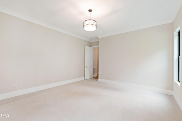 spare room with ornamental molding and light colored carpet