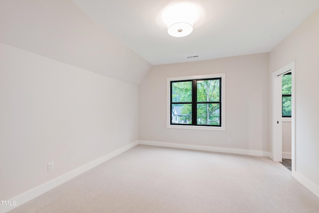 additional living space featuring carpet floors and vaulted ceiling