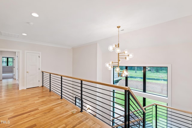 hall featuring wood-type flooring and a notable chandelier