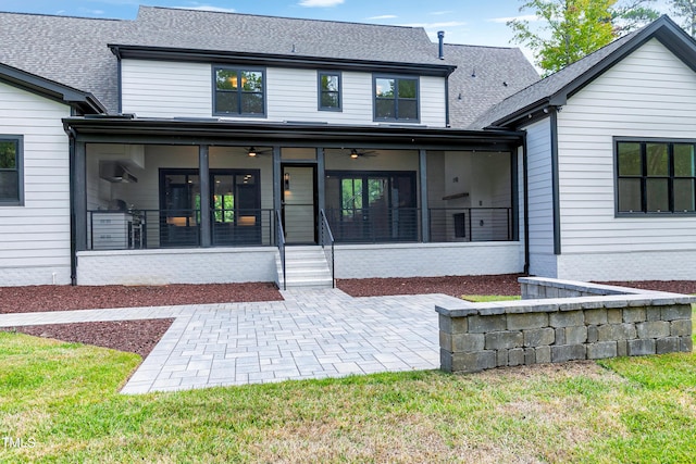 rear view of house with ceiling fan, a sunroom, a yard, and a patio