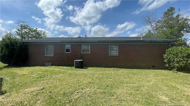 rear view of house featuring crawl space, a lawn, brick siding, and cooling unit